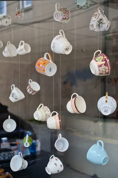 Suspended cups and mugs in the window of MoveHome Estate Agents